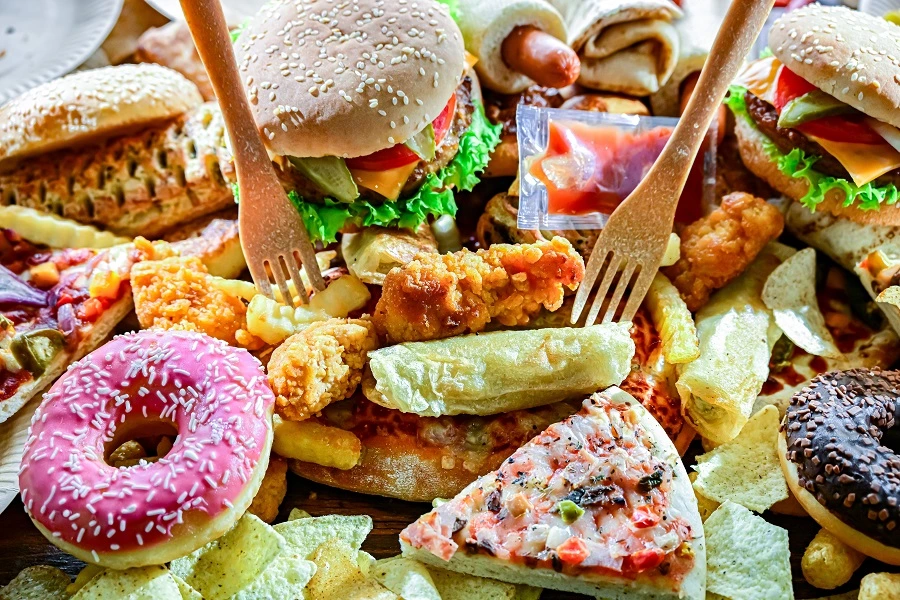 pizza burgers and donuts with two wooden forks